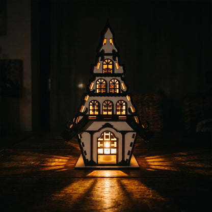 Căsuță decorativă iluminată pe un raft de bibliotecă